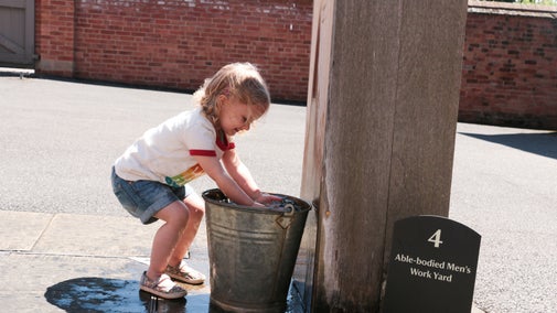 Young girl using a waterpump